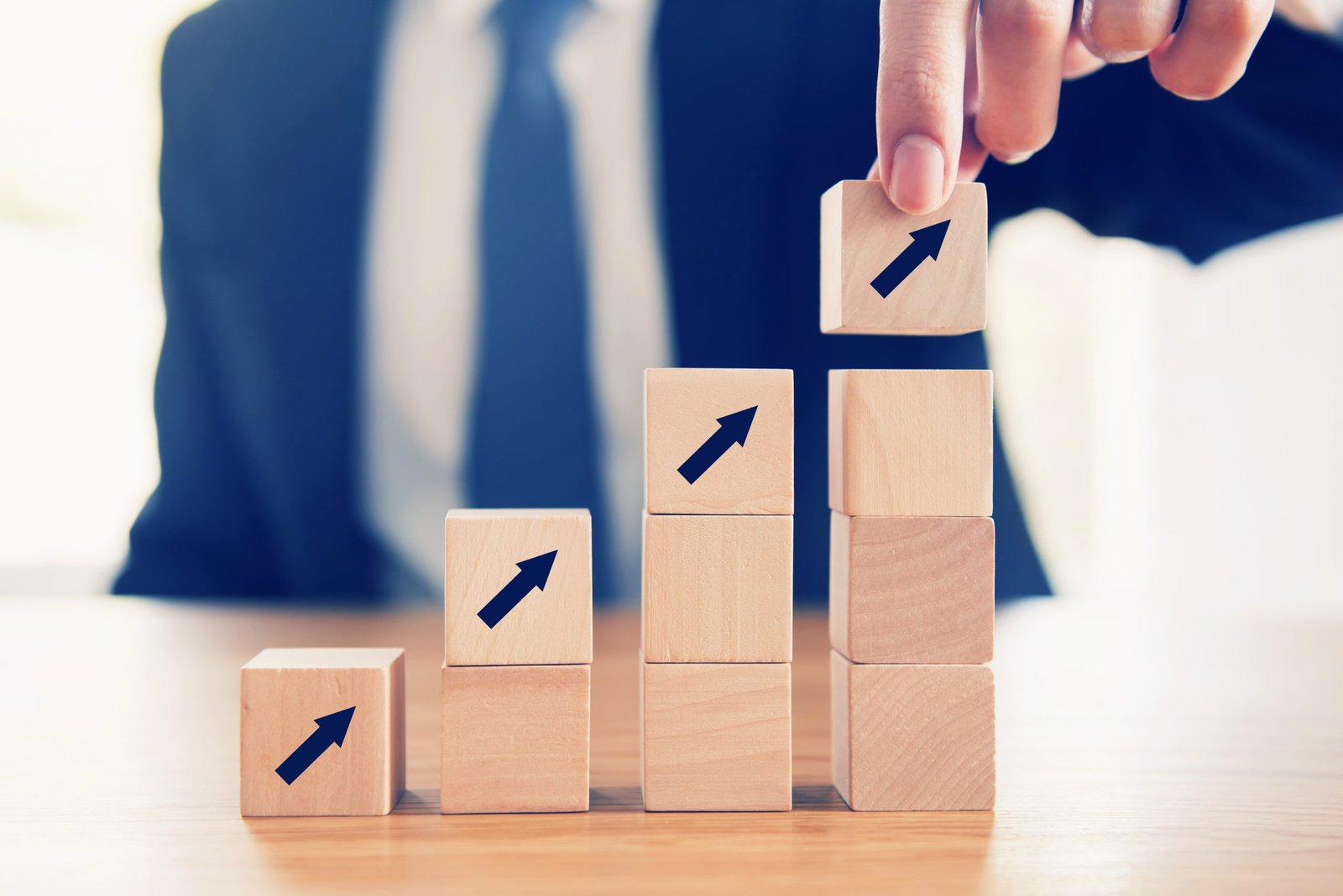 business-concept-growth-success-process-close-up-businessman-hand-arranging-wood-cube-with-arrow-stacking-as-step-stair